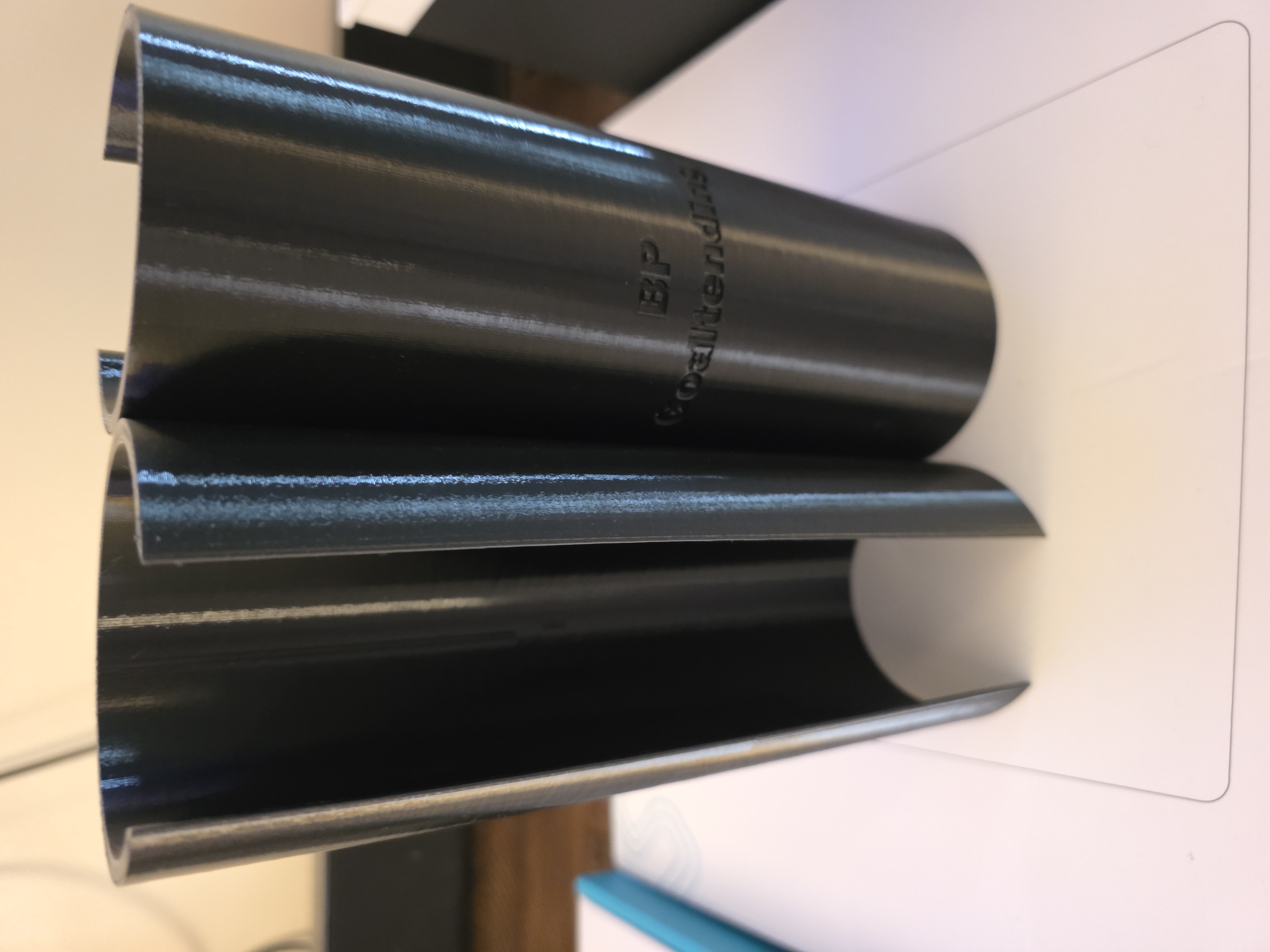 Two black cylindrical 3D-printed BP Goaltending goal post sleeves